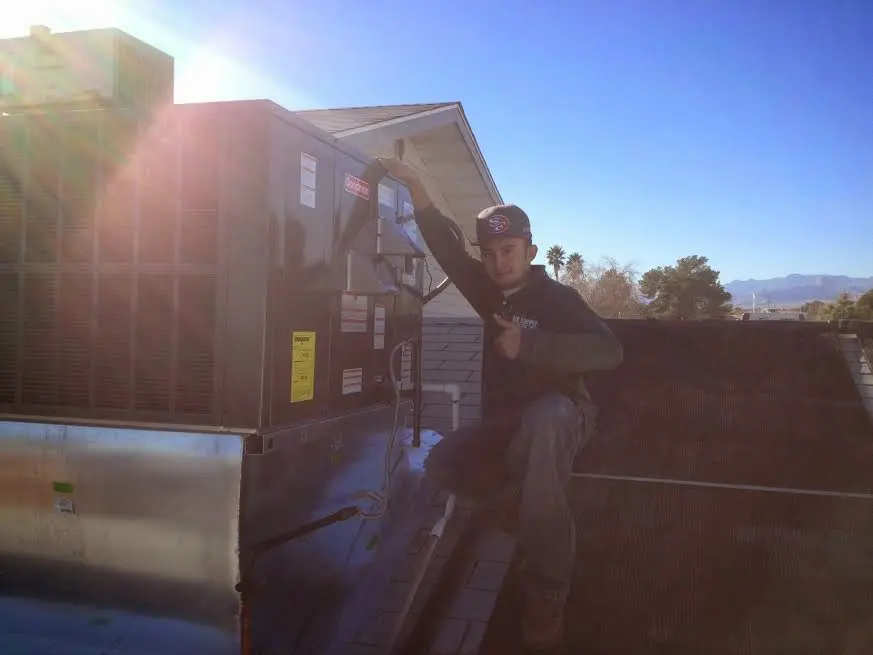 HVAC technician performing Heat Pump Repair on a rooftop unit in Red Bluff